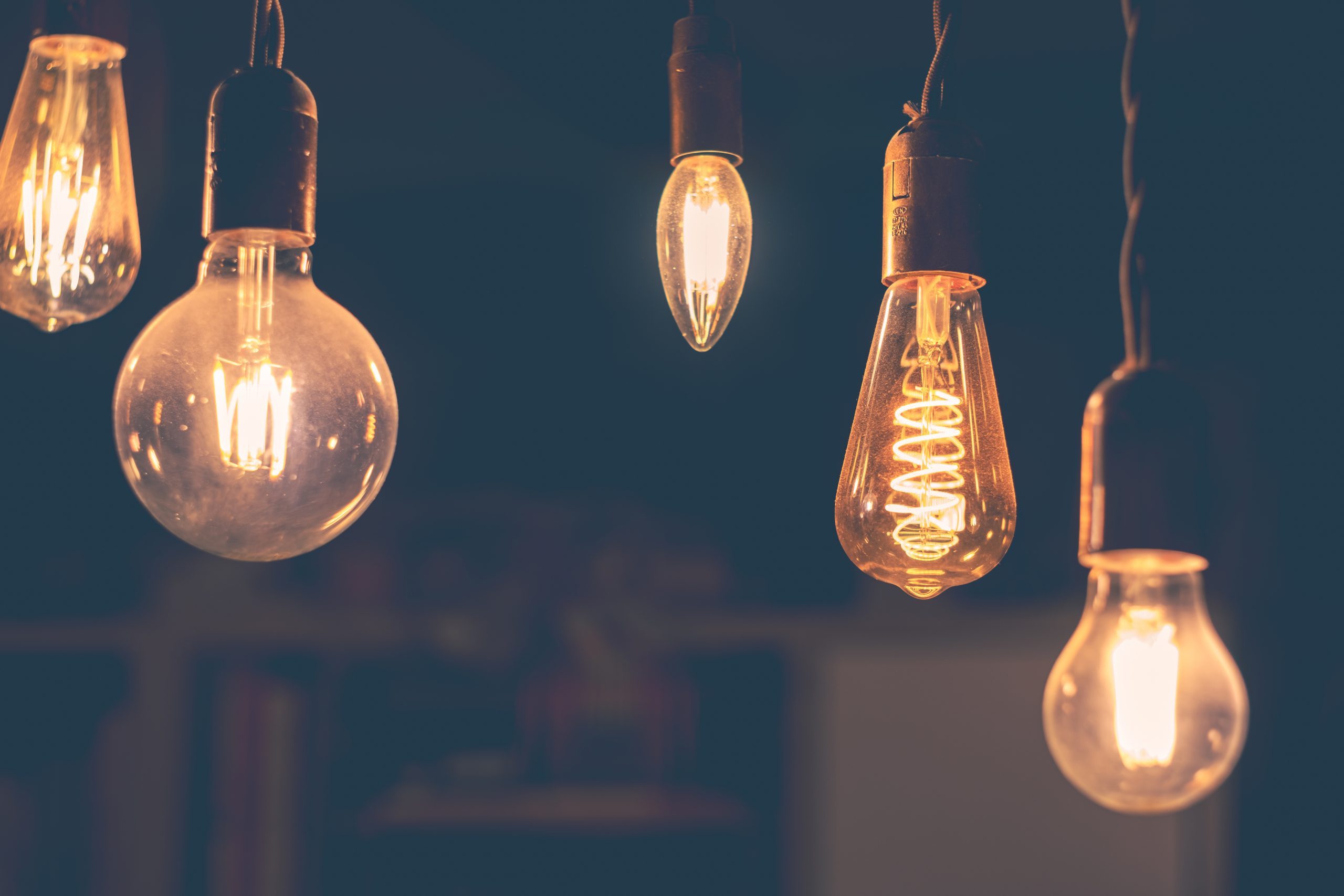 Retro light bulbs hanging on a dark background. Electricity, Vintage Retro LED light bulbs hanging on a dark background in interior. Electricity, Vintage
